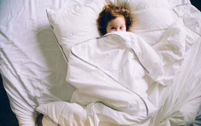 Boy in bed under covers