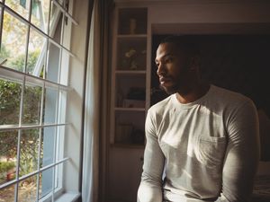 Pensive man looking out window