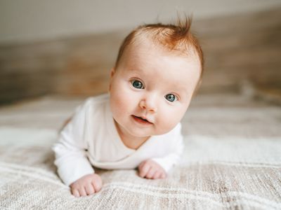 Baby crawling on bed smiling