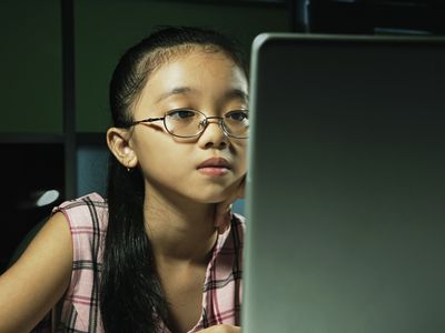 Schoolgirl (10-12) using laptop computer, close-up