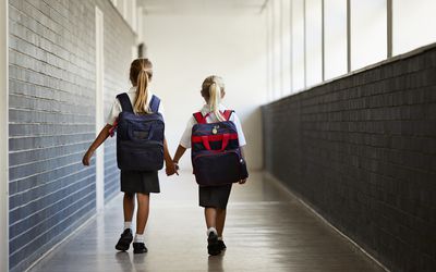 在校园里，女学生们手牵手走在路上