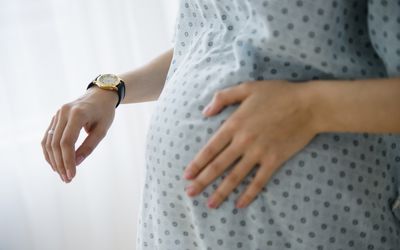 Pregnant Caucasian woman timing contractions in hospital