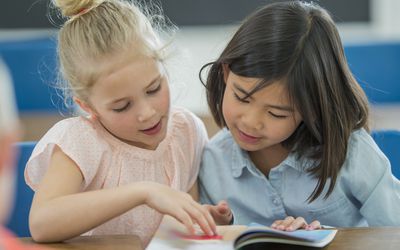 两个小学同学在看一本书
