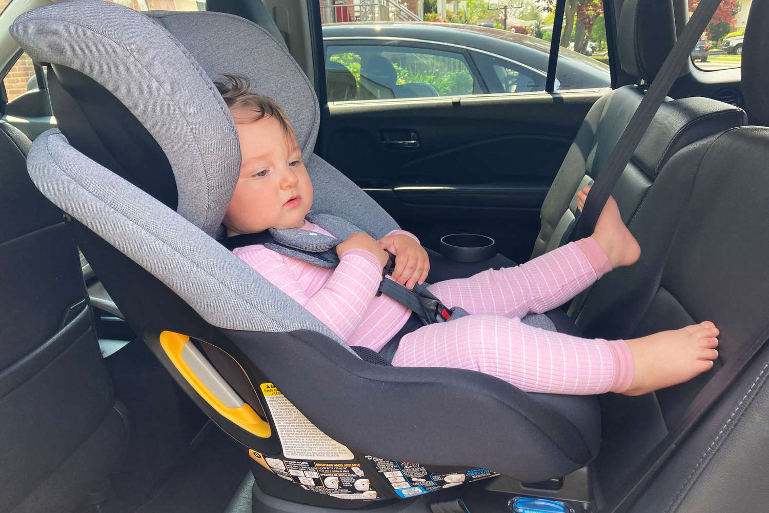 A child sits in the Baby Jogger City Turn Rotating Convertible Car Seat