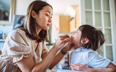 家长用棉签擦拭孩子的鼻子