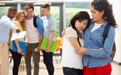 Female teen helping another who is being bullied