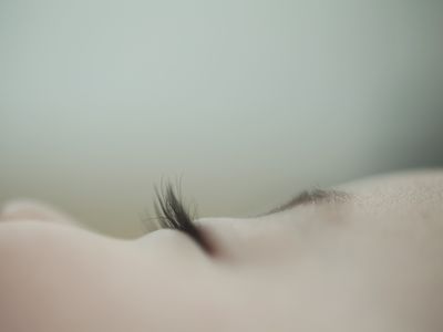 Close-up of white baby's face sleeping. Eyelashes prominent, slight view of the tail end of the eyebrows