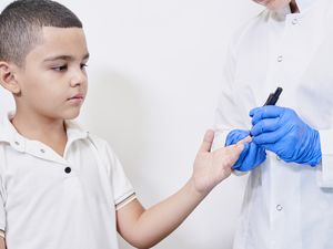护士在给小男孩做糖尿病检查。