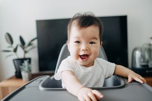 亚洲婴儿坐在高脚椅上。