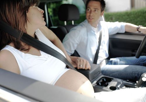 一个男人开车载着一个孕妇