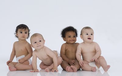 四个多民族的婴儿坐在白人身上
