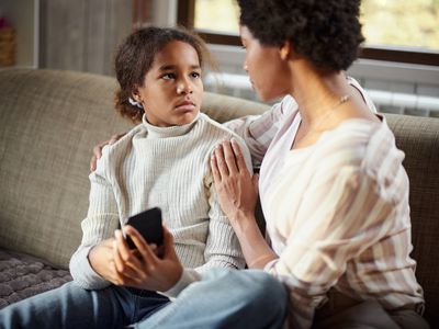 Sad girl talking to her mother at home