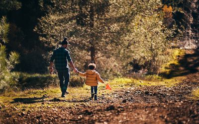 Father and son with rain boots and net going fishing