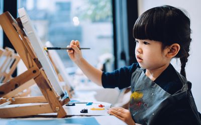 A toddler experimenting with color during their art class