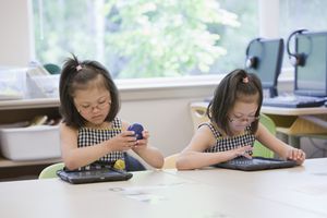 双胞胎女孩在教室里使用平板电脑
