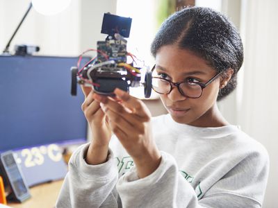 Teenage girl building robot from subscription box