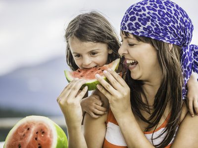 Mother and daughter eating watermelon