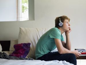 Teenage boy listening to music on a mobile phone.