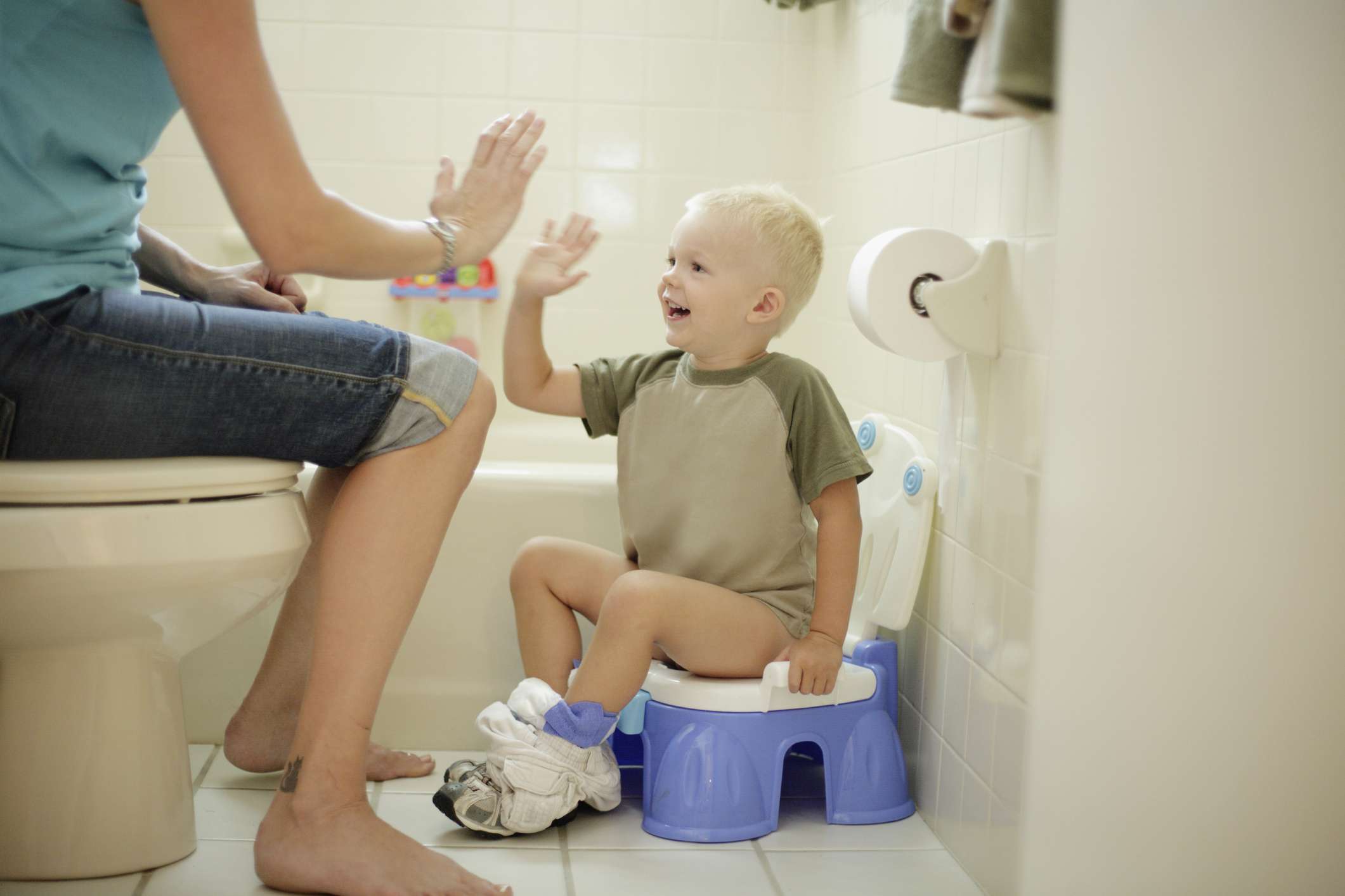 Mother and son high-fiving after he uses the potty