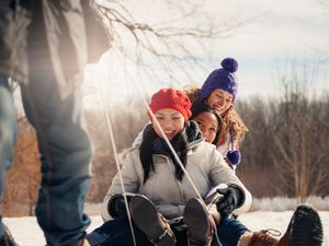 Teenagers being pulled on a sled