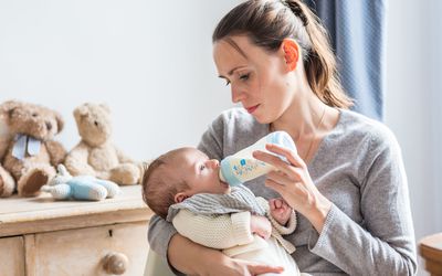 妇女用奶瓶喂婴儿