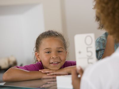 Woman showing girl math flashcards