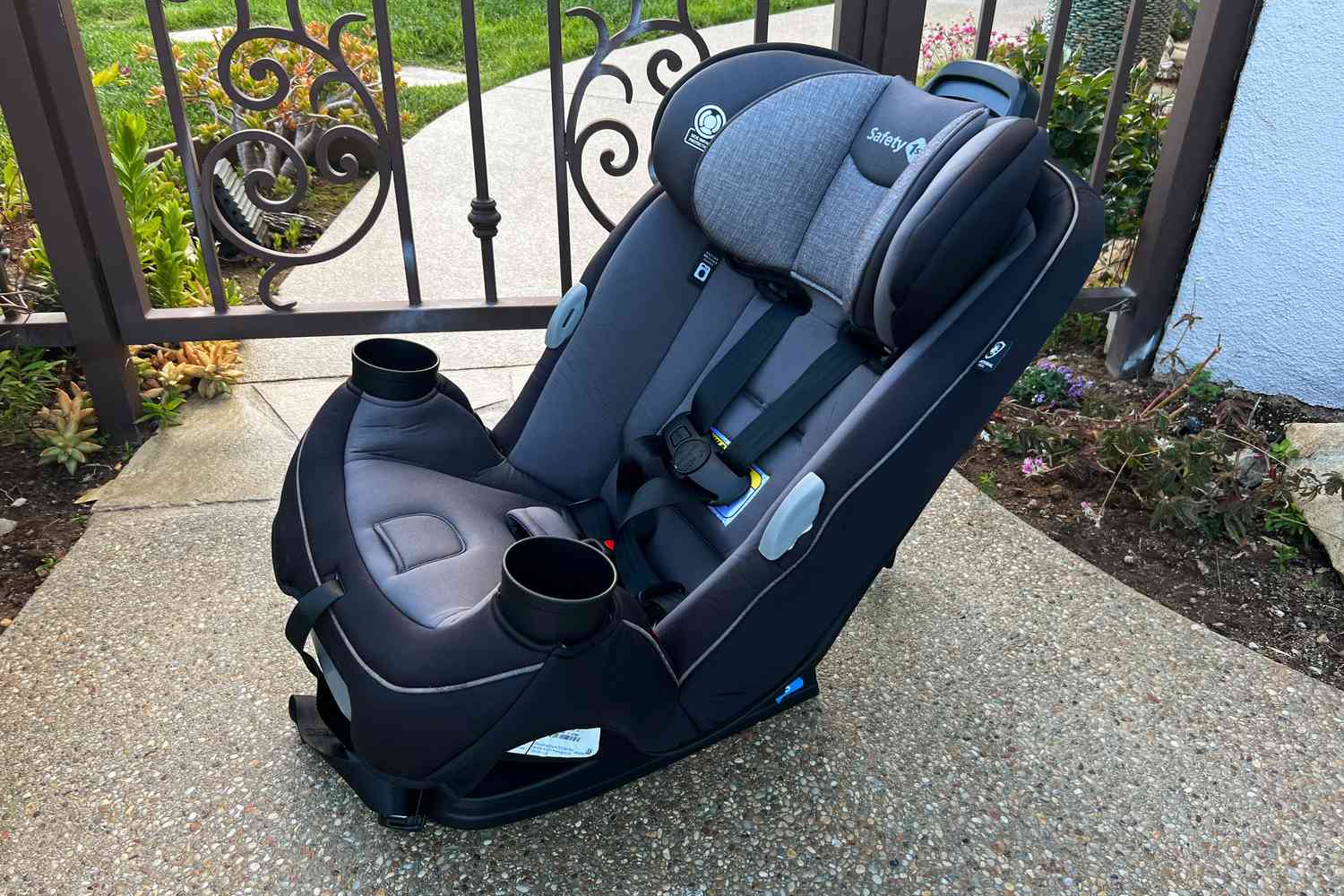 Safety 1st Grow and Go All-in-One Convertible Car Seat displayed on sidewalk in front of gate