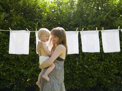 mother and baby in front of diapers on clothesline