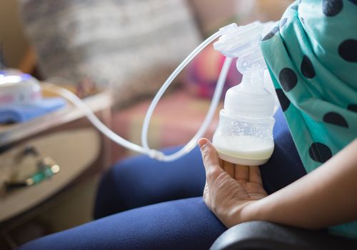 Nursing mother using automatic breast pump