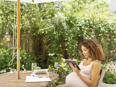 Pregnant woman reading in garden