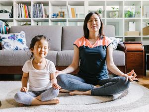 Woman doing yoga with her daughter