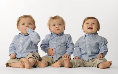 三胞胎，三个男孩坐在地板上，双胞胎和三胞胎是生育药物可能的风险/副作用