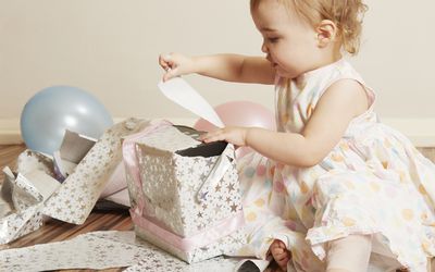 two year old girl opening a present