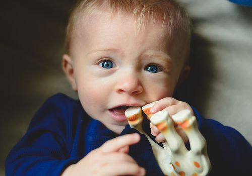 Baby chewing on toy