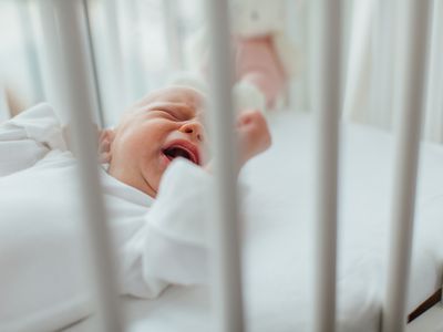 Baby girl lying in crib crying