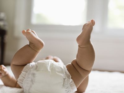 Mixed race baby girl laying on floor