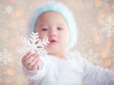 baby holding a snowflake