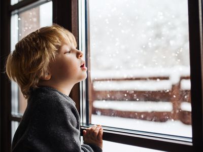 Young boy looking out at the snow