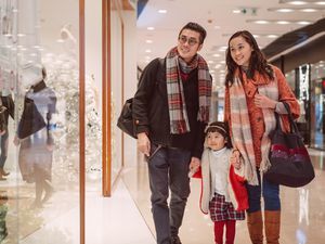 一对夫妇带着女儿在购物中心圣诞购物