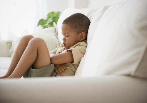 a boy sitting on a sofa having a time out