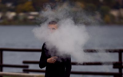 Teenager in a cloud of vape smoke