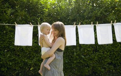 母亲和婴儿在晾衣绳上的尿布前