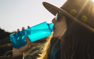 徒步旅行中的女子用水瓶喝水