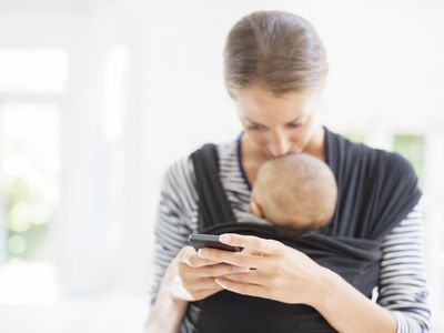 A picture of a mother kissing her baby and uploading something on social media