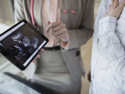 doctor showing fetus on ultrasound on tablet