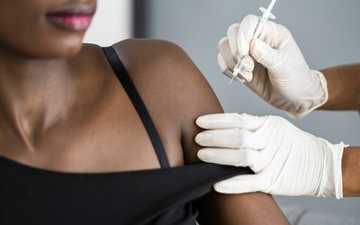 非洲裔美国妇女正在接种covid-19疫苗＂width=