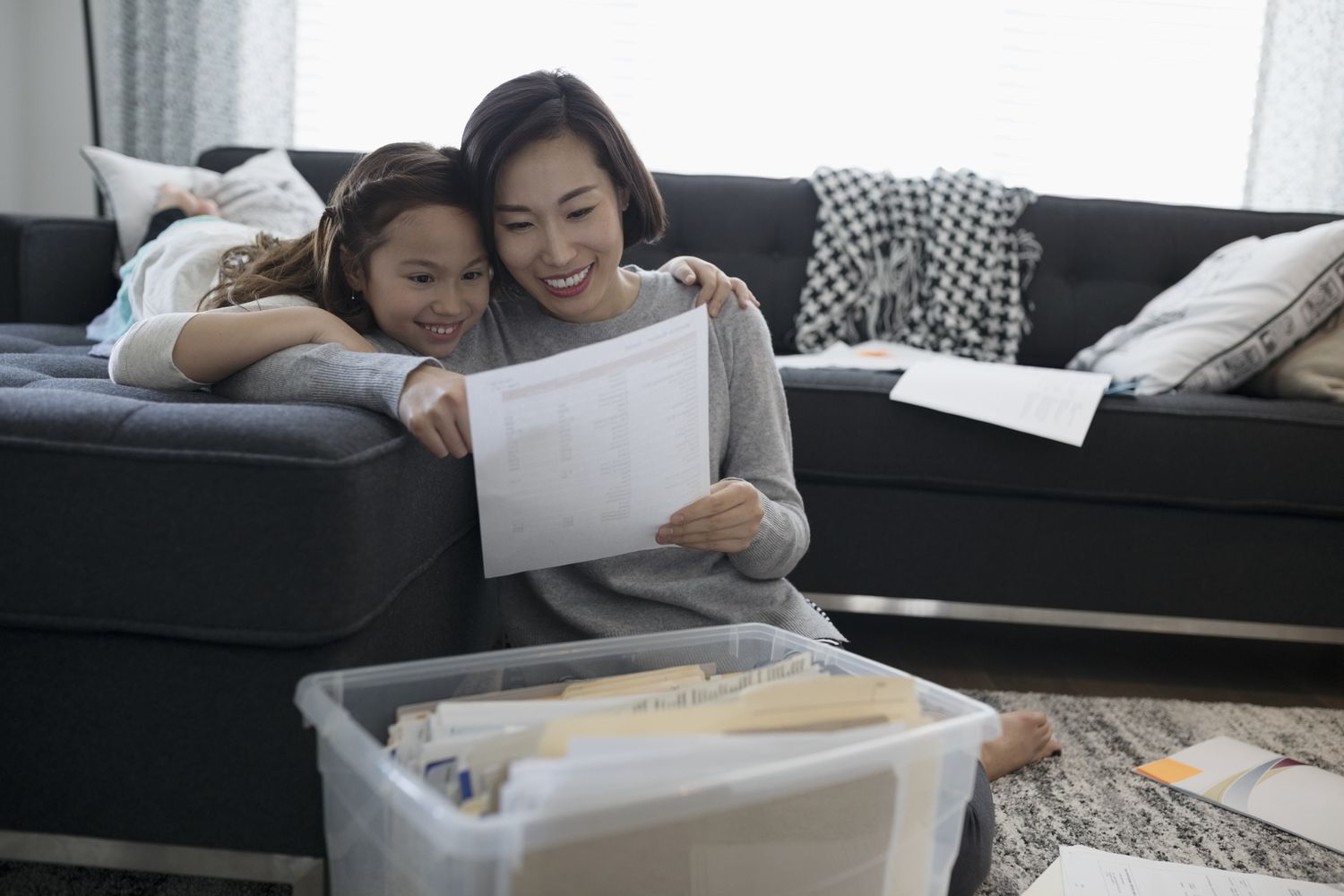 Mother and daughter viewing financial paperwork in living room