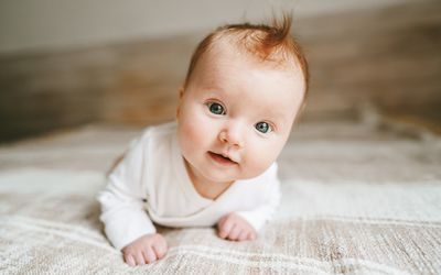 Baby crawling on bed smiling