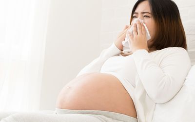 孕妇用纸巾捂着鼻子