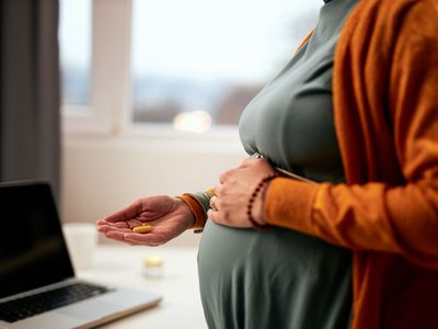 Pregnant woman taking prenatal vitamins